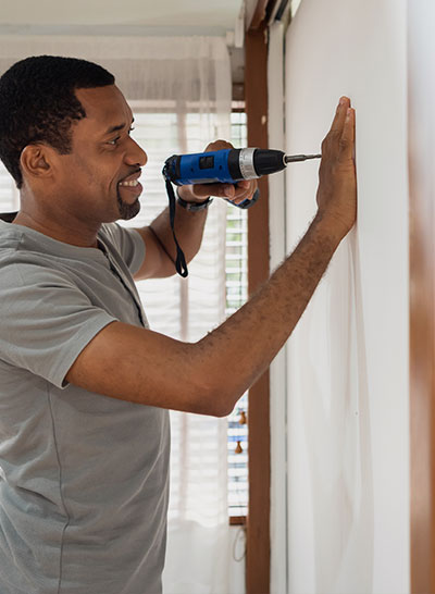 A man drilling something into a wall